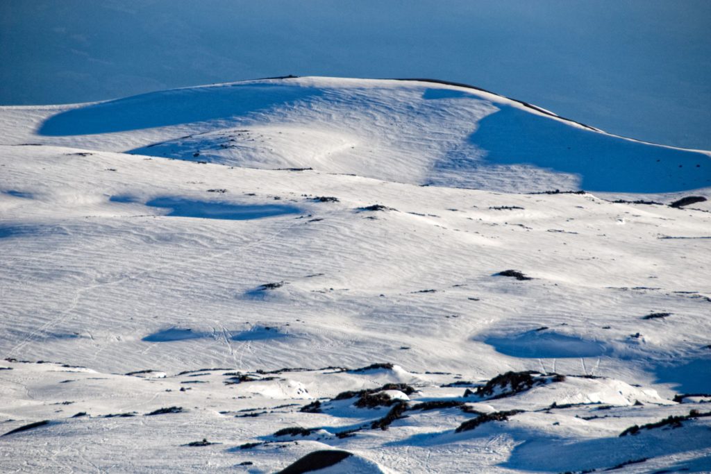 A photo of Mauna Kea on the Big Island of Hawaii, its peak capped with snow.