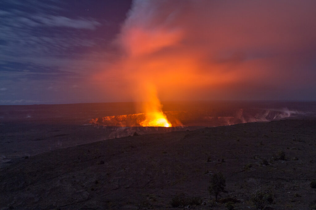 Night view of Kilauea volcano crater with flowing lava.