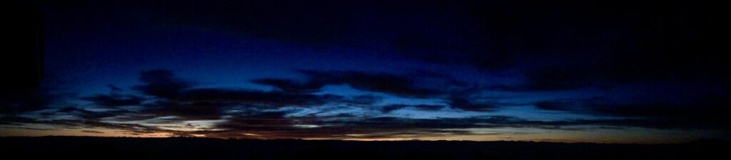 A panoramic night view of Haleakala Crater on Maui, showcasing the vast crater bathed in moonlight.